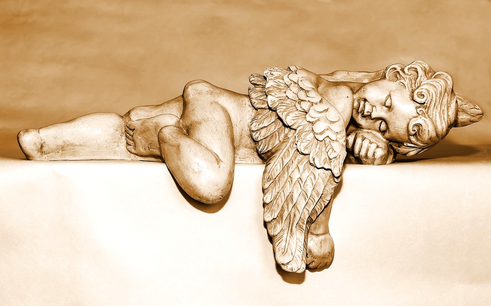 Stone cherub laying on stone
